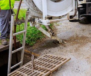 Sewage cleaning workers equipment with sewer on a town street on industrial truck