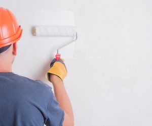 Painter On Stepladder Painting Wall With Brush